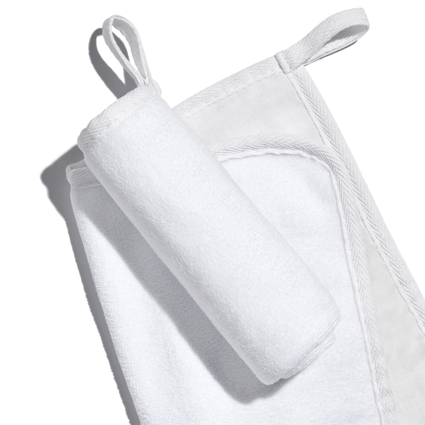 White, banded, Lisa Eldridge Luxuriously Gentle Cleansing & Exfoliating Cloth, one flat and one rolled up on top, showing different textures of the cloth faces and a loop for hanging up