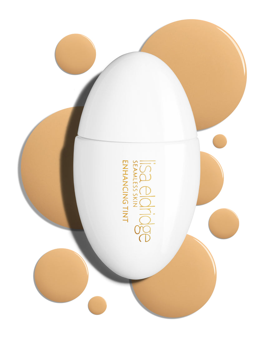 The white pod packaging of Seamless Skin Enhancing Tint by Lisa Eldridge with drops of T6.5 in the background