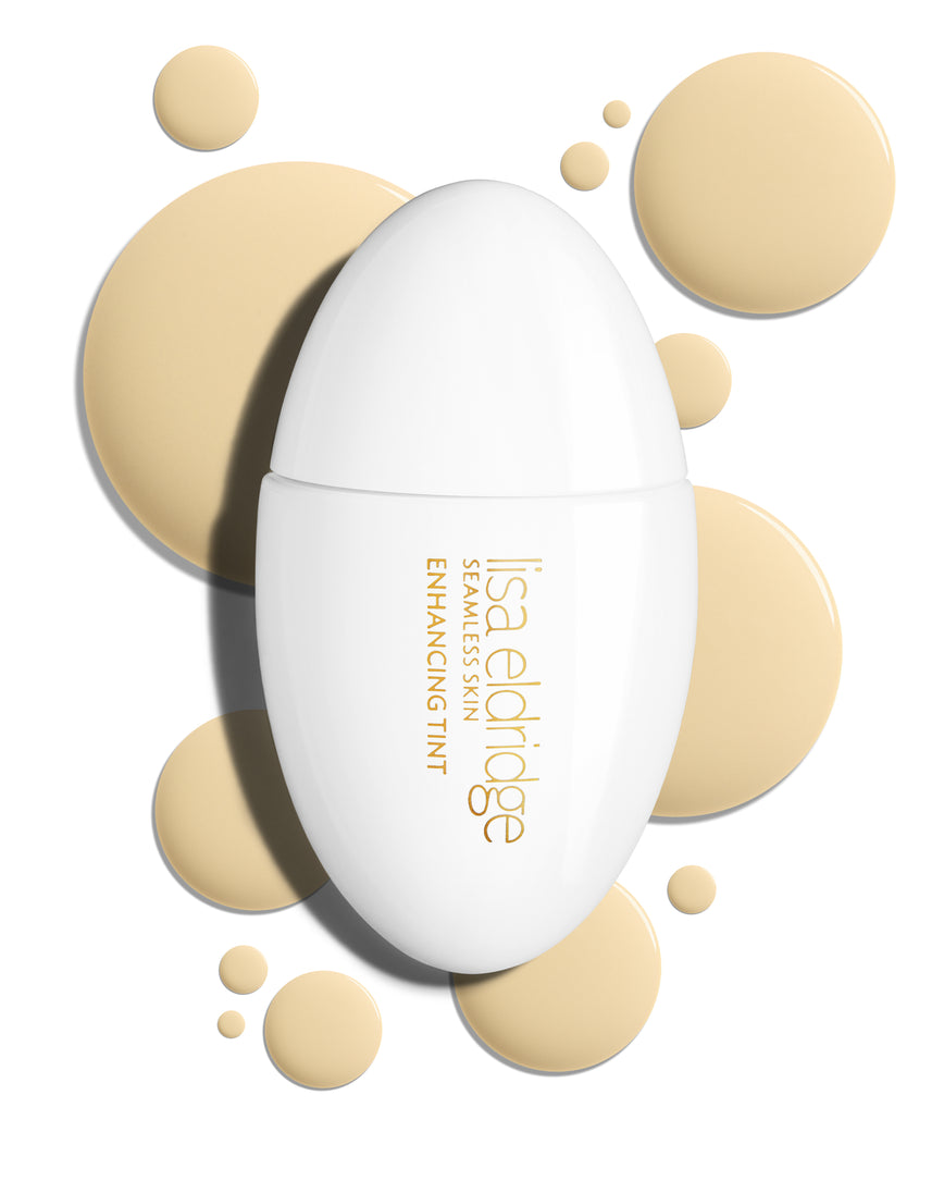 The white pod packaging of Seamless Skin Enhancing Tint by Lisa Eldridge with drops of T1.5 in the background