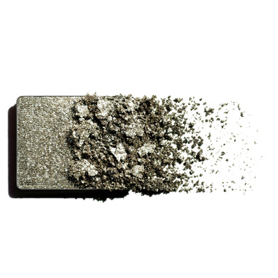 Makeup eyeshadow refill with green shimmer powder on a white background