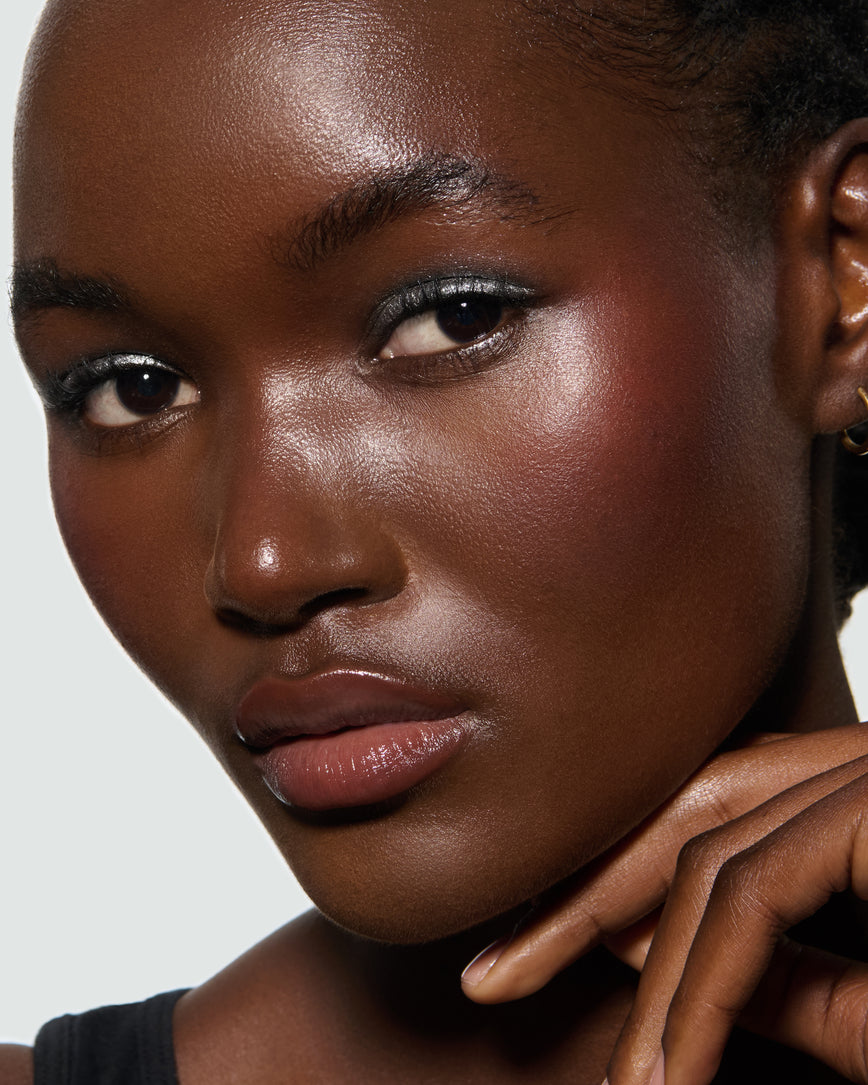 Close-up of a model's face, against a neutral background, wearing Aria Liquid Lurex Liquid Eyeshadow, a true, cool, clear silver.