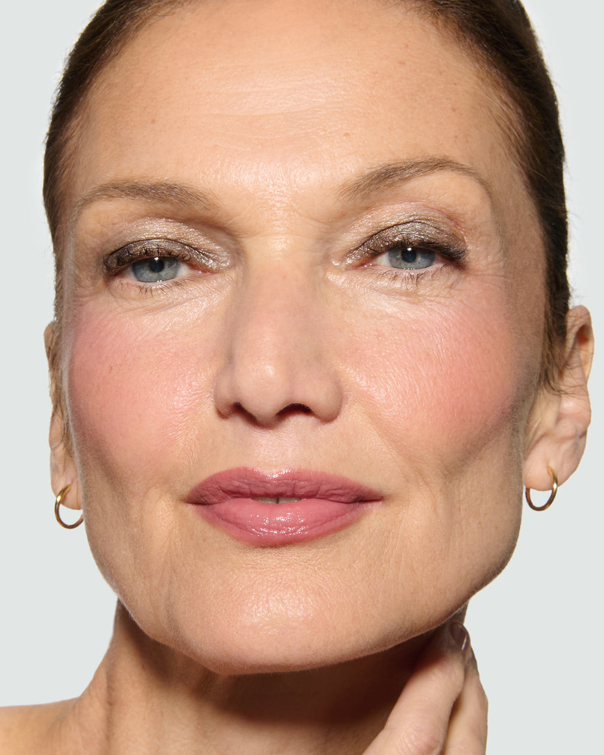 Close-up of a model's face against a neutral background, wearing Selene Liquid Lurex Liquid Eyeshadow, a tarnished, cool toned greenish/silver.