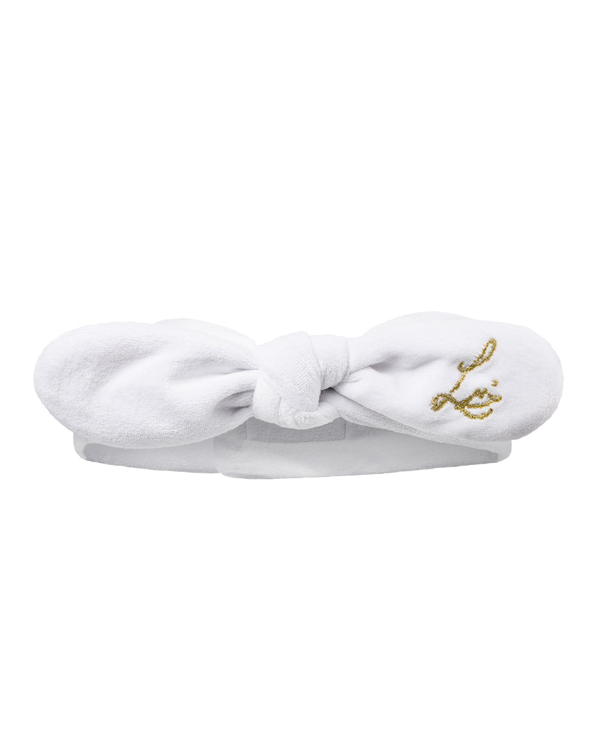 White headband with gold Lisa Eldridge monogram on a white background