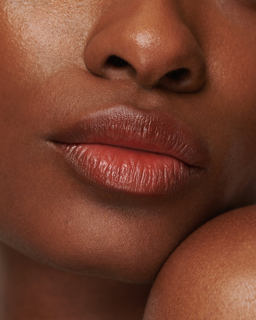 Extreme close up of model's lips, wearing Red Curve Baume Embrace