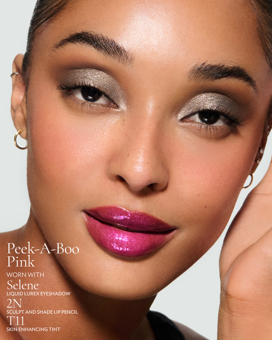 Close-up of a model's face against a neutral background, wearing Peek-A-Boo Pink Gloss Embrace Sequin, with Selene Liquid Lurex, 2N Sculpt and Shade Pencil, and T11 Skin Enhancing Tint.