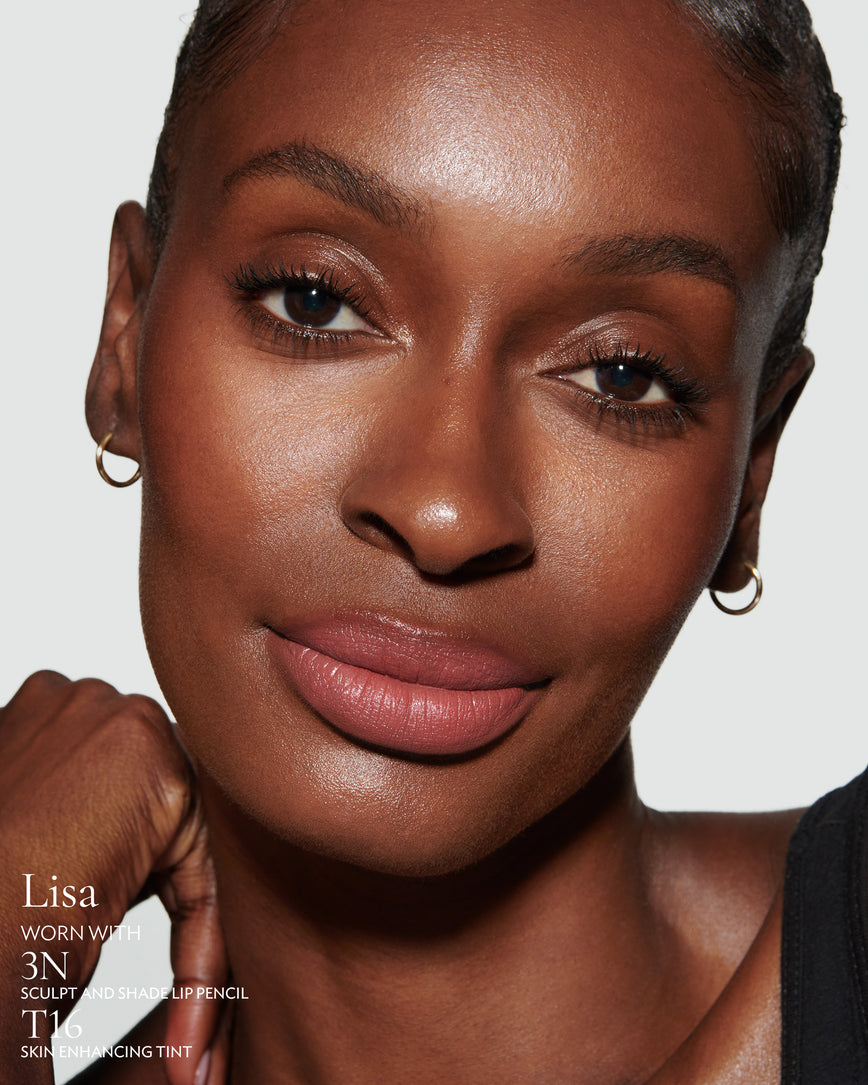 Close-up of a woman with a grey background, focusing on the lip colour - neutral pink Lisa, with notes on the 3N Sculpt and Shade Pencil and T16 Skin Enhancing Tint
