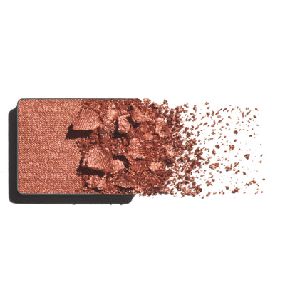 Makeup eyeshadow refill with warm copper powder on a white background
