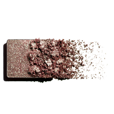 Makeup eyeshadow refill with green to heather monochromatic powder on a white background