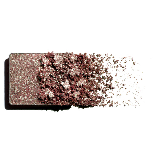 Makeup eyeshadow refill with green to heather monochromatic powder on a white background