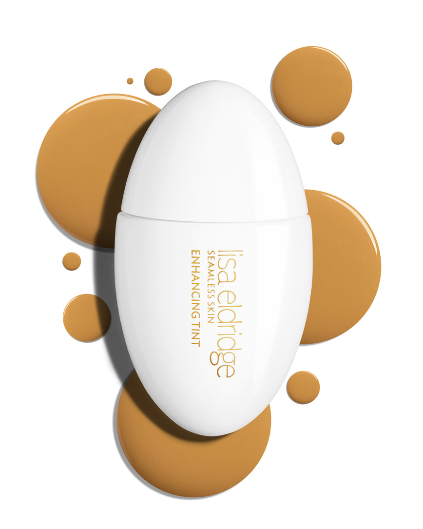 The white pod packaging of Seamless Skin Enhancing Tint by Lisa Eldridge with drops of T10 in the background