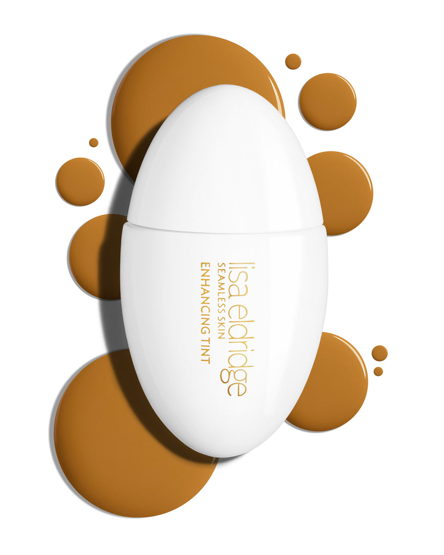 The white pod packaging of Seamless Skin Enhancing Tint by Lisa Eldridge with drops of T12 in the background