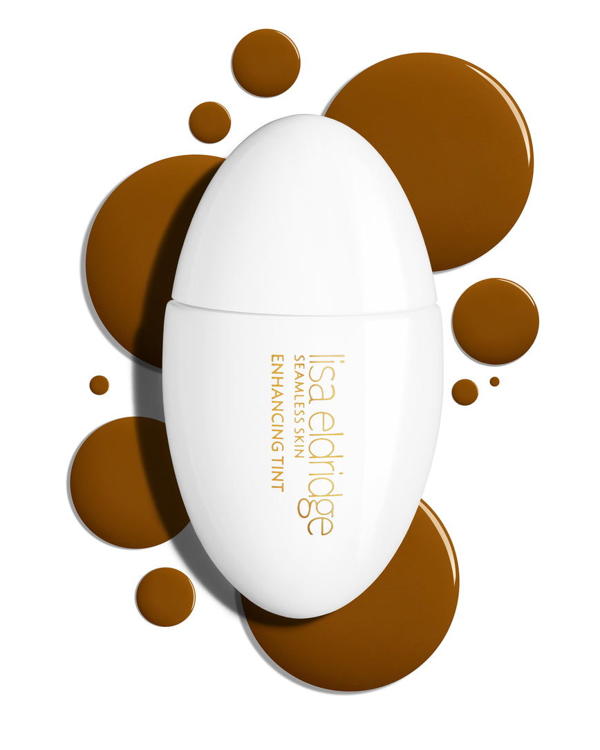 The white pod packaging of Seamless Skin Enhancing Tint by Lisa Eldridge with drops of T15 in the background