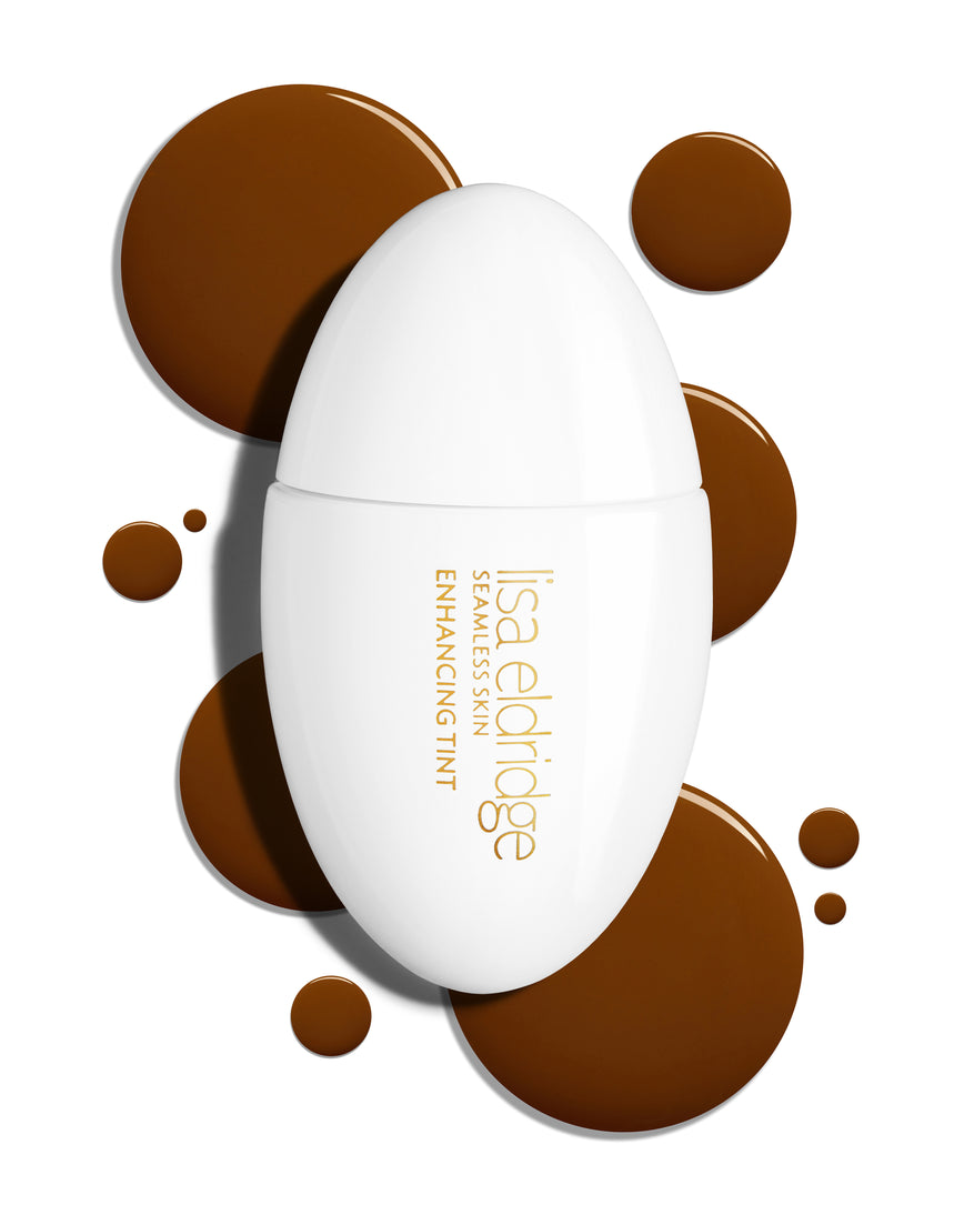 The white pod packaging of Seamless Skin Enhancing Tint by Lisa Eldridge with drops of T16 in the background
