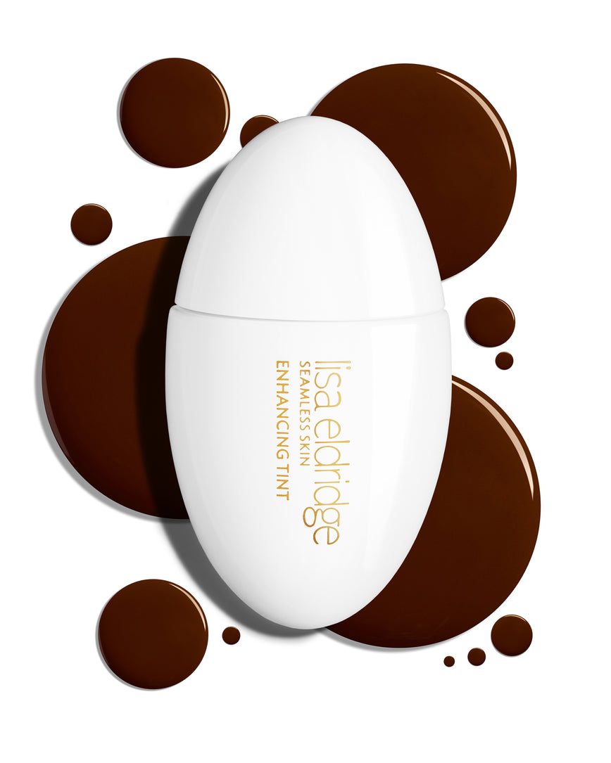 The white pod packaging of Seamless Skin Enhancing Tint by Lisa Eldridge with drops of T17 in the background