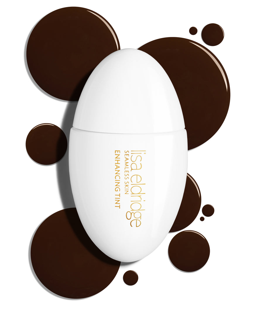 The white pod packaging of Seamless Skin Enhancing Tint by Lisa Eldridge with drops of T18 in the background