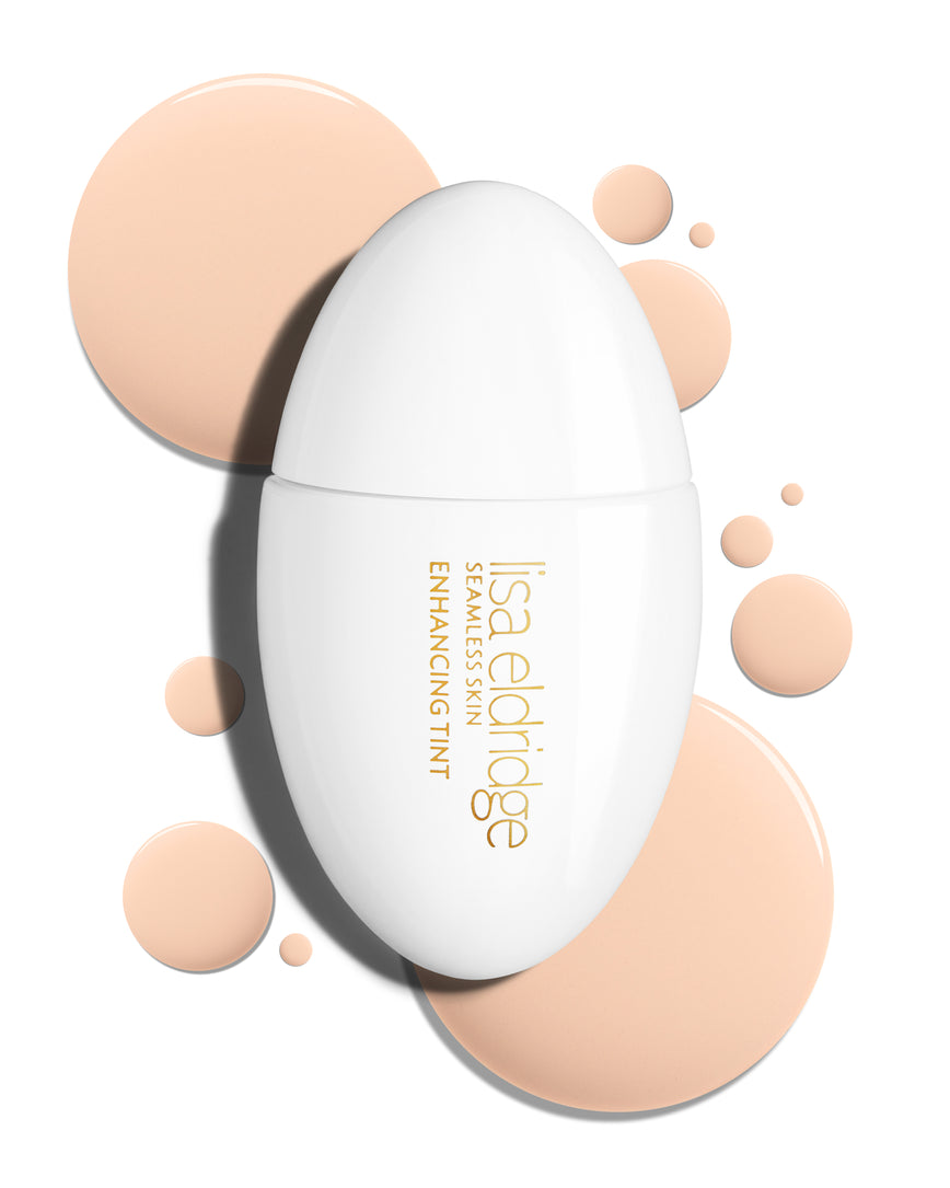 The white pod packaging of Seamless Skin Enhancing Tint by Lisa Eldridge with drops of T1 in the background