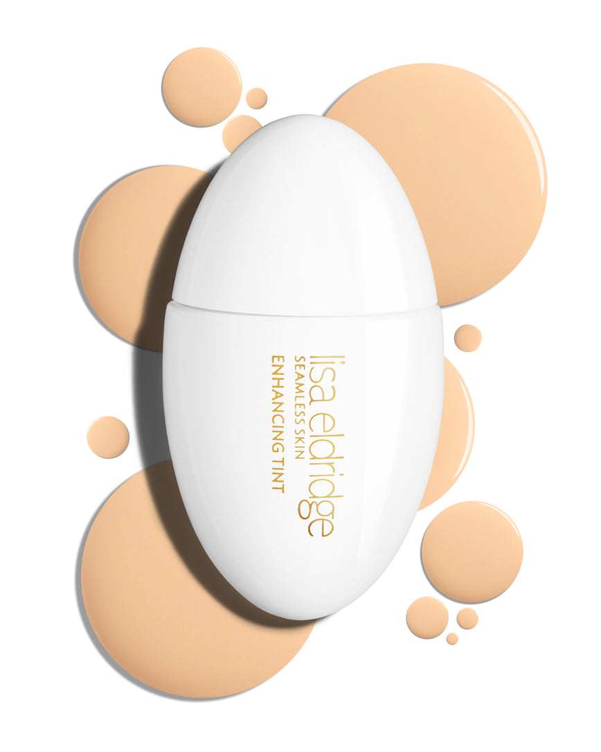 The white pod packaging of Seamless Skin Enhancing Tint by Lisa Eldridge with drops of T2 in the background