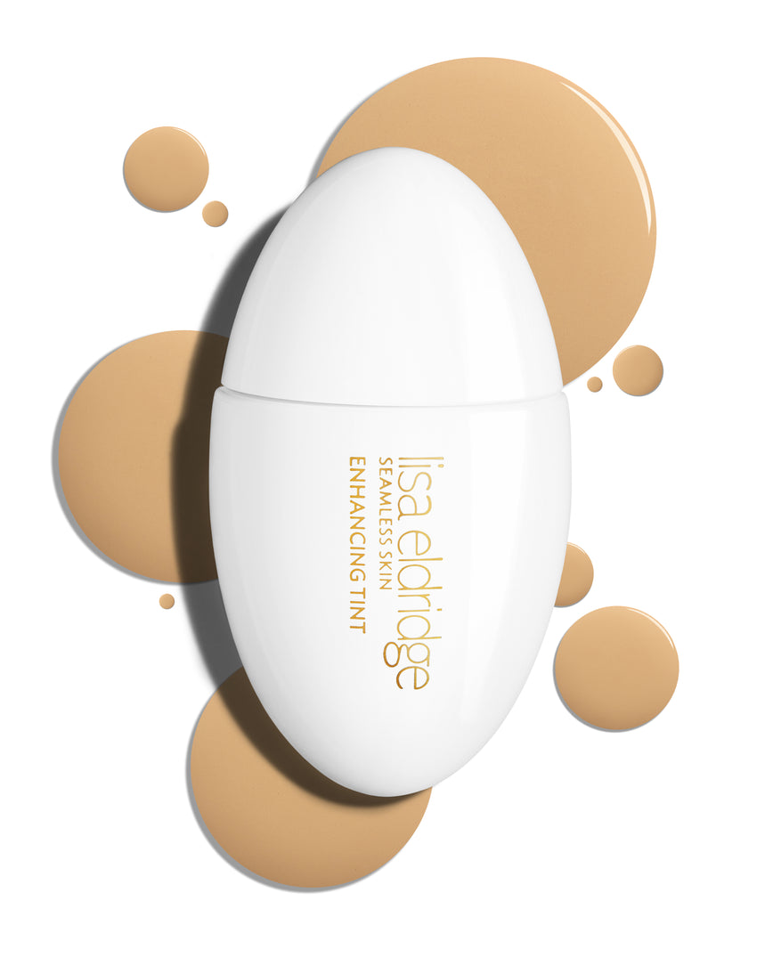The white pod packaging of Seamless Skin Enhancing Tint by Lisa Eldridge with drops of T6 in the background
