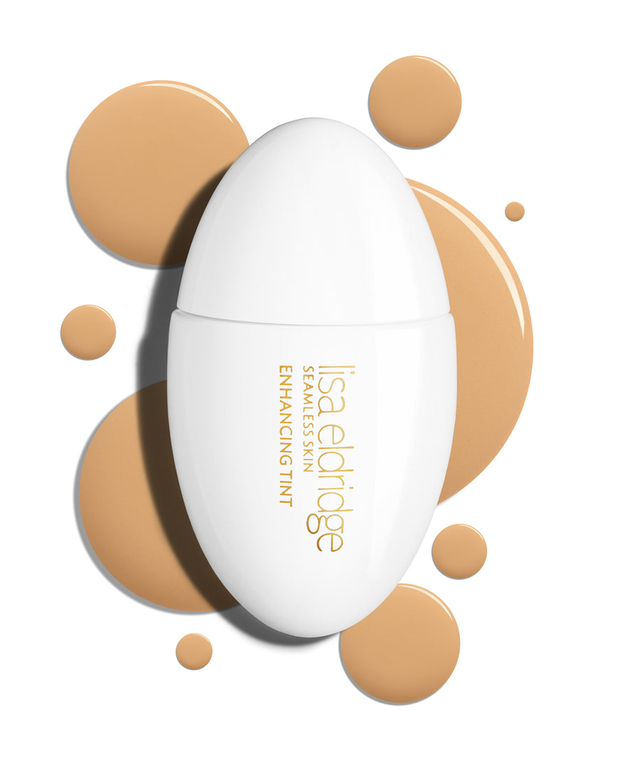 The white pod packaging of Seamless Skin Enhancing Tint by Lisa Eldridge with drops of T7 in the background