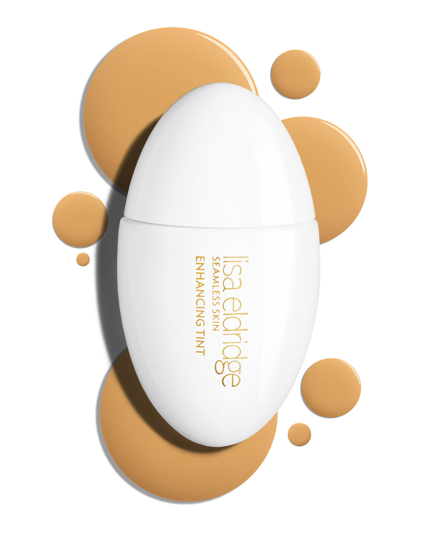 The white pod packaging of Seamless Skin Enhancing Tint by Lisa Eldridge with drops of T8 in the background