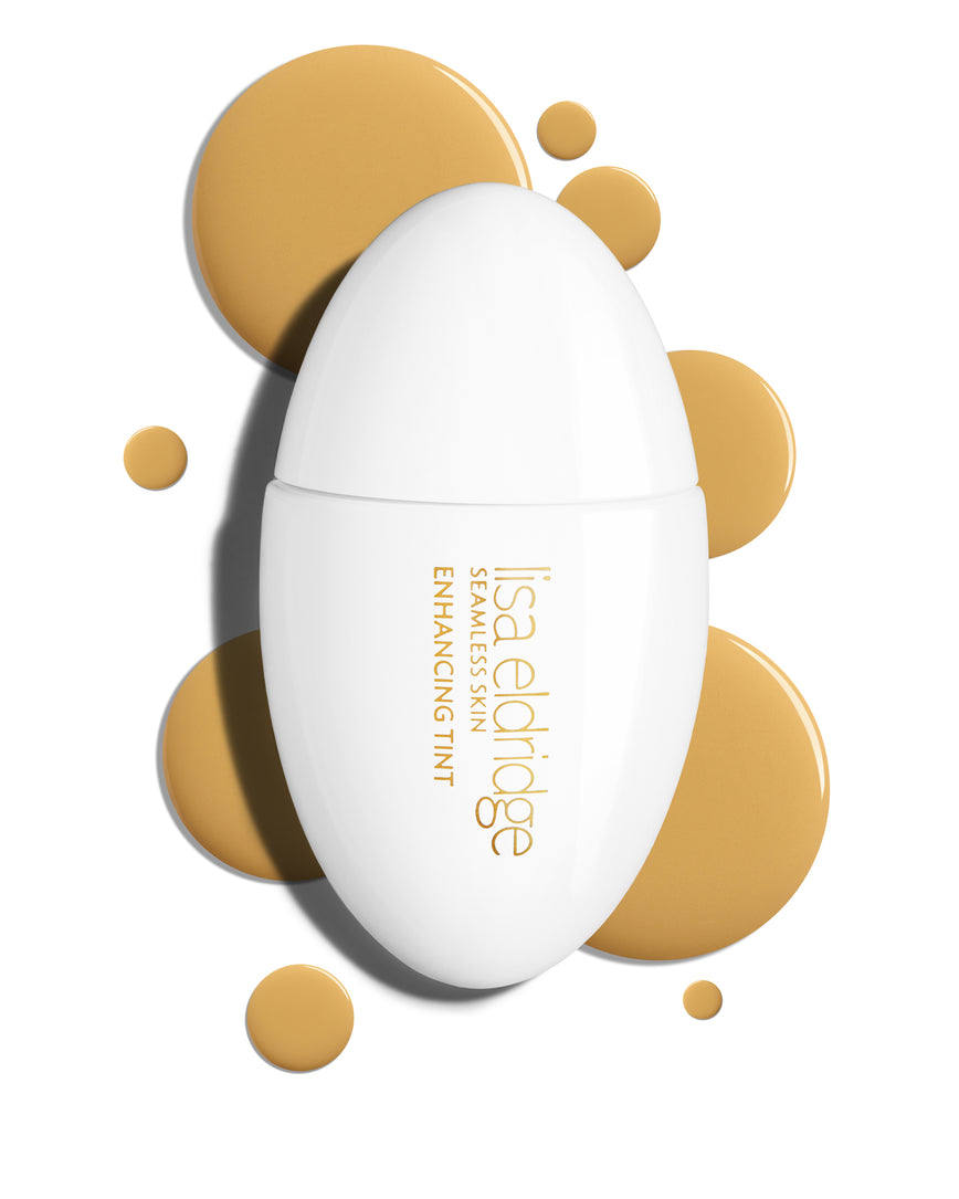 The white pod packaging of Seamless Skin Enhancing Tint by Lisa Eldridge with drops of T9 in the background
