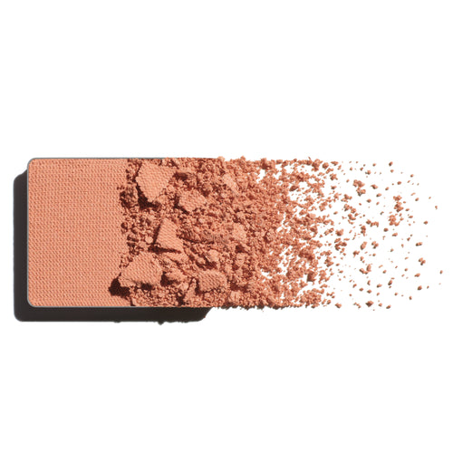 Makeup eyeshadow refill with soft apricot powder on a white background